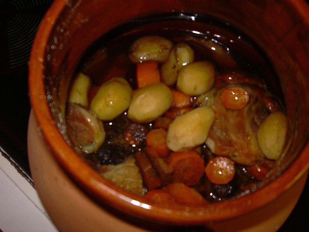 Dans un plat en terre cuite vernissée, les morceaux de viande et légumes carottes, pomme de terre) ont mijoté dans le vin rouge.