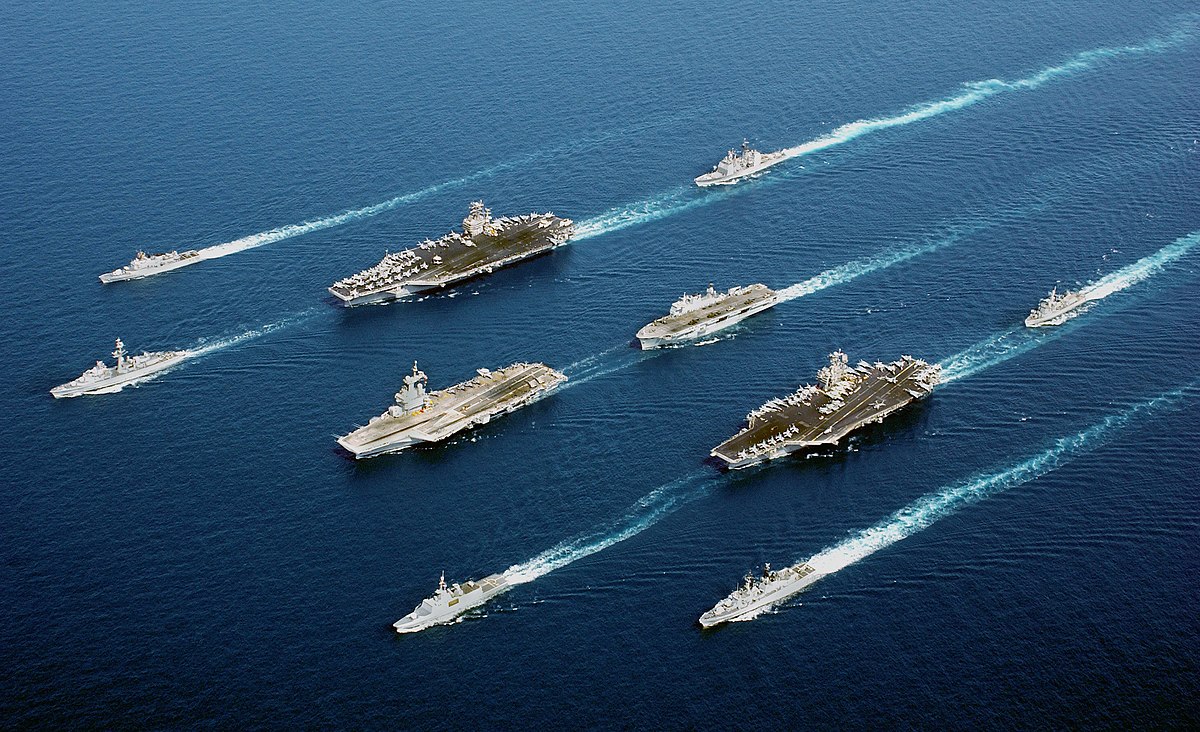 Image de bâtiments de 5 nations engagées dans l'opération Enduring Freedom en mer d'Oman. En 4 colonnes, de en haut à gauche à en bas à droite : ITS Maestrale (F 570), FS De Grasse (D 612), USS John C. Stennis (CVN 74), USS Port Royal (CG 73), FS Charles de Gaulle (R 91), HMS Ocean (L 12), FS Surcouf (F 711), USS John F. Kennedy (CV 67), HNLMS Van Amstel (F 831), et ITS Luigi Durand de la Penne (D 560) (18 avril 2002)