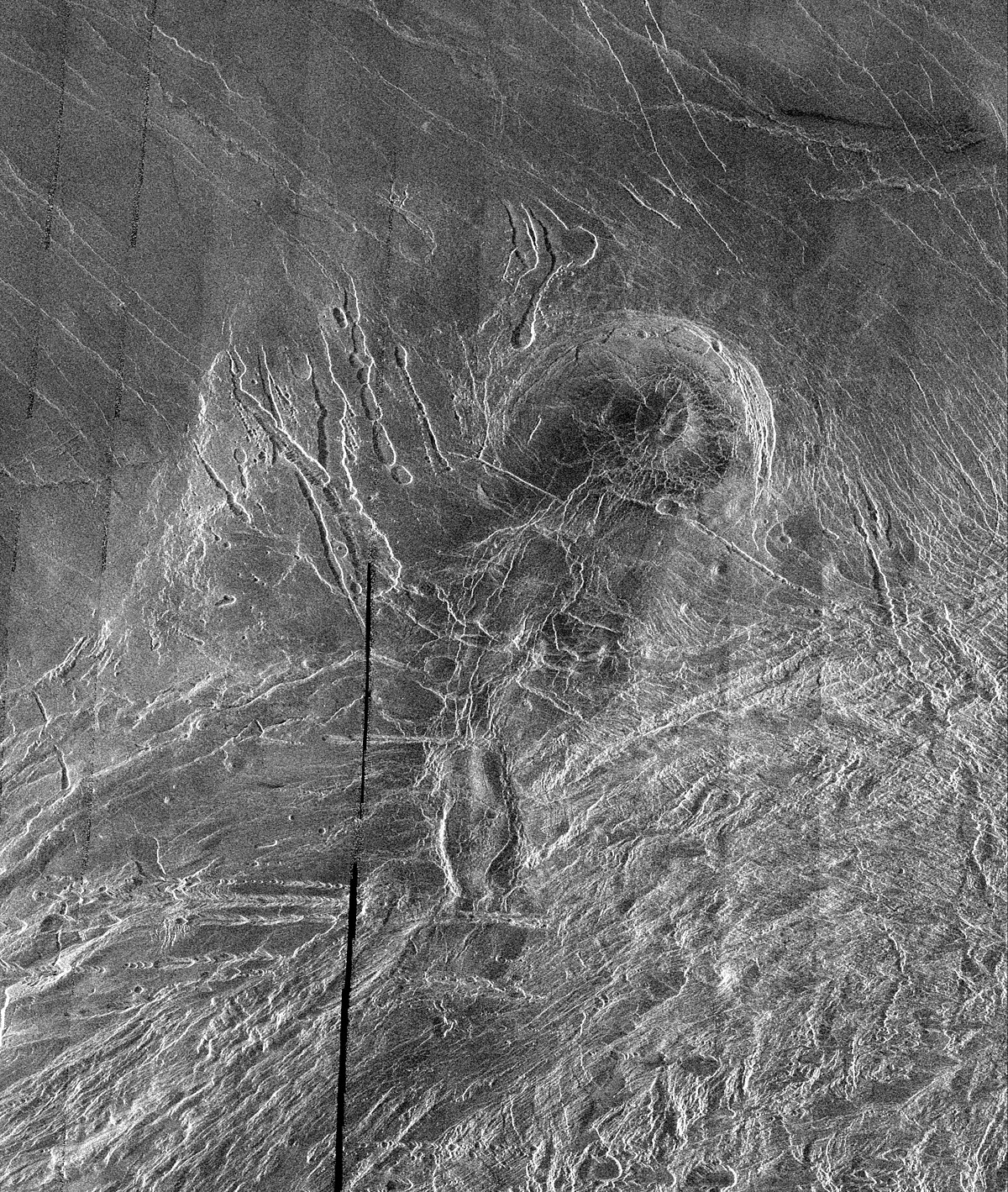Image radar du sud de Lakshmi Planum montrant, au sud, le début de Clotho Tessera et, au nord, les surfaces lisses de Lakshmi. La structure circulaire au centre, Siddons Patera, serait une caldeira volcanique, et les creux allongés sur la gauche seraient des cavités résultant de l'effondrement de tubes de lave.