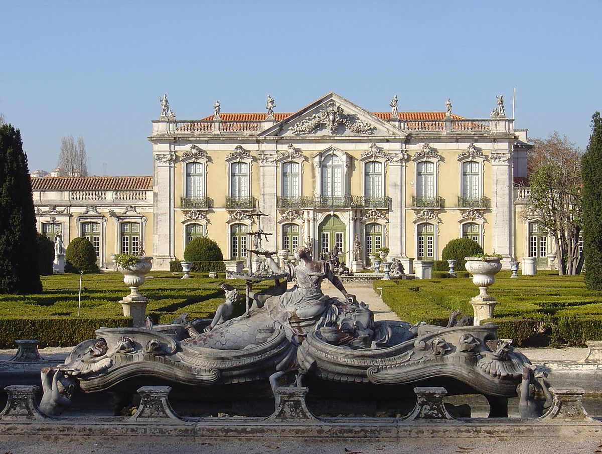 La façade de cérémonie du palais de Queluz, édifice de caractère néo-classique, avec une fontaine rococo au premier plan.