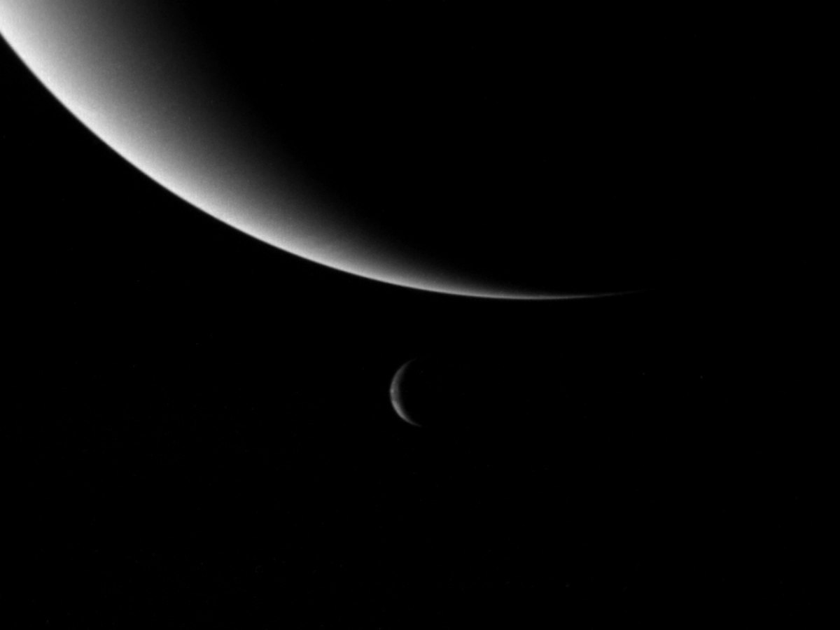 Une petite partie de la planète Neptune et sa lune Triton, beaucoup plus petite