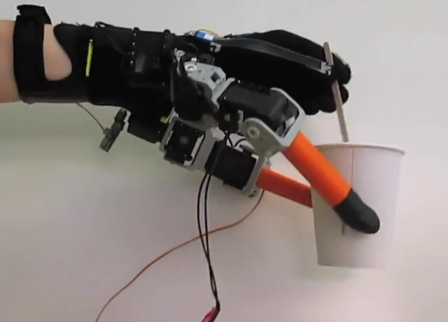 Une main à sept doigts, cinq plus deux robotisés