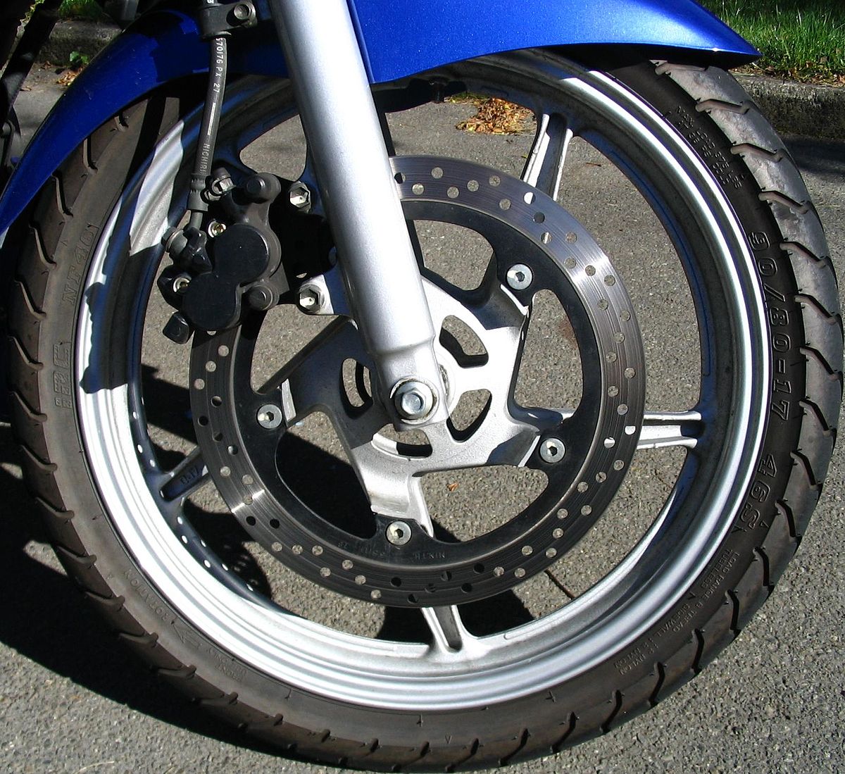 Un frein à disque de moto. Ce disque est perforé, l'étrier est à double piston. Sa commande est hydraulique.