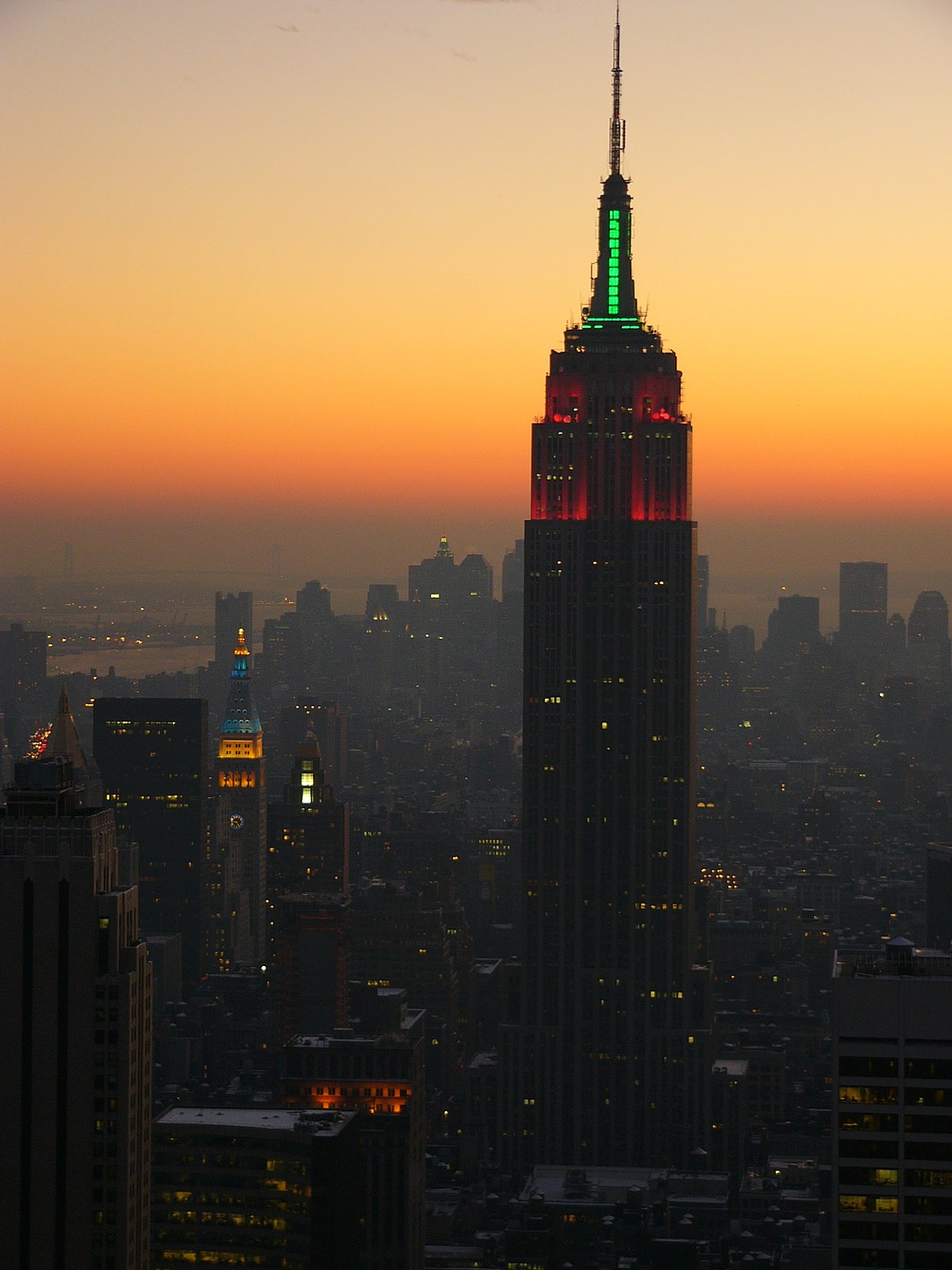 L’Empire State Building éclairé de vert et de rouge, à l'occasion des fêtes de fin d'année. On aperçoit la Metropolitan Life Tower elle aussi éclairée, en bleu et en jaune.