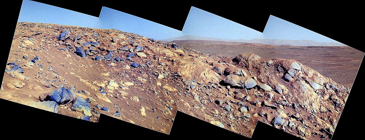 Fond du cratère Gusev, en arrière plan, vu depuis le sommet d'une des collines de Columbia Hills par le rover Spirit lors de son 210e jour de présence sur Mars. L'image est en fausses couleurs.