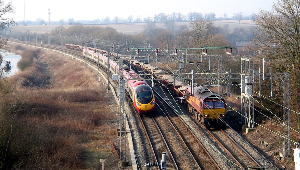 Train entier de matériaux en wagons-trémies d'EWS croisant un Pendolino de Virgin sur la West Coast Main Line (Royaume-Uni).