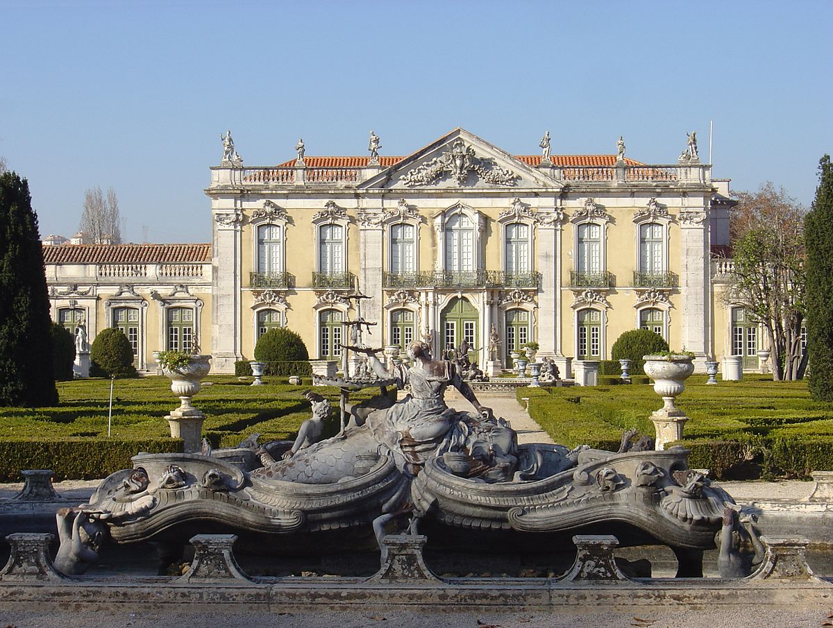La façade de cérémonie du palais de Queluz, édifice de caractère néo-classique, avec une fontaine rococo au premier plan.