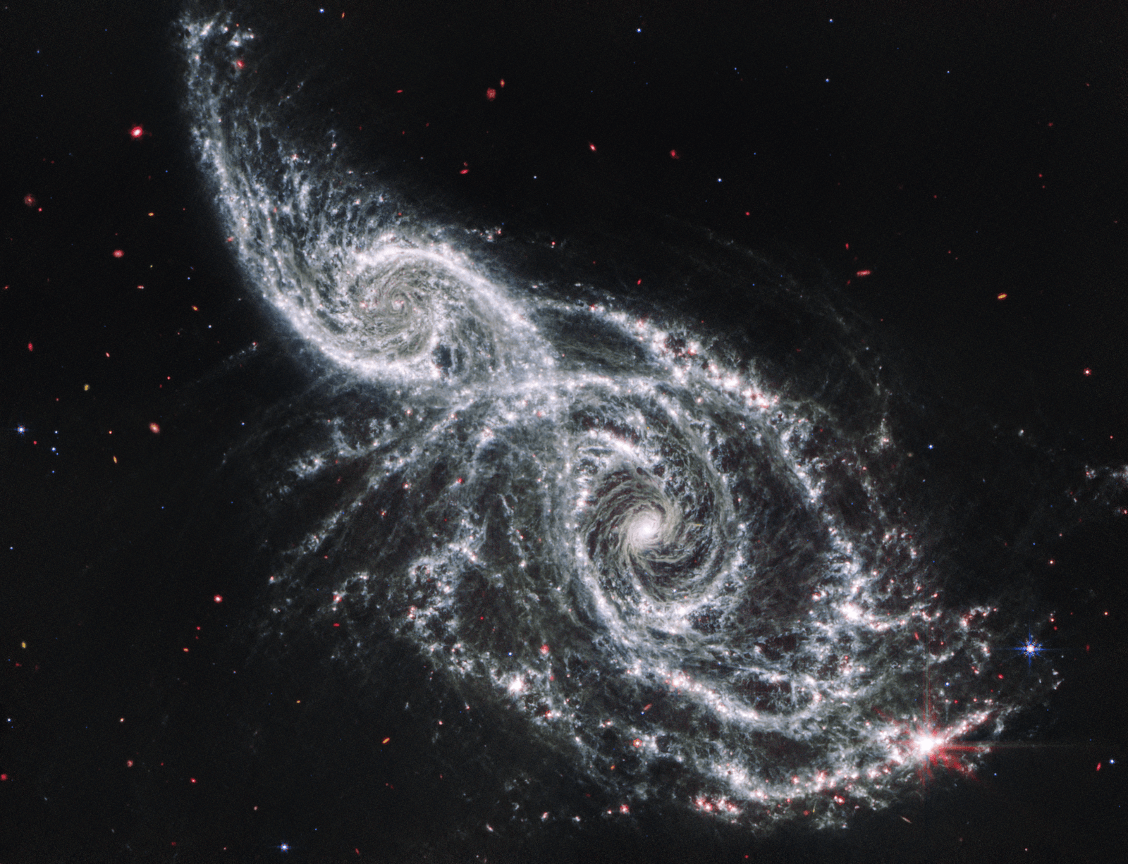 Les galaxies IC 2163 et NGC 2207 observées par MIRI, dont l'infrarouge moyen met en évidence la poussière et les régions de formation d'étoiles.