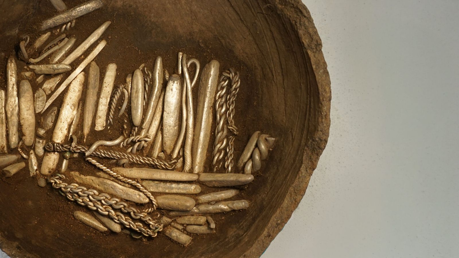 Une partie du trésor d’argent viking de Rebild encore contenue dans le récipient en terre cuite où elle avait été enfouie.