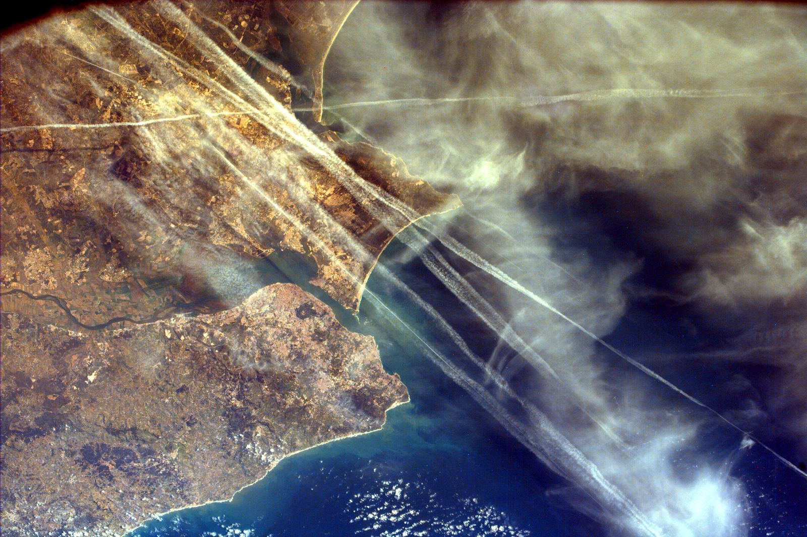 Des traînées de condensation traversent le ciel au-dessus de Lisbonne, photographiées depuis la navette spatiale en février 2000.
