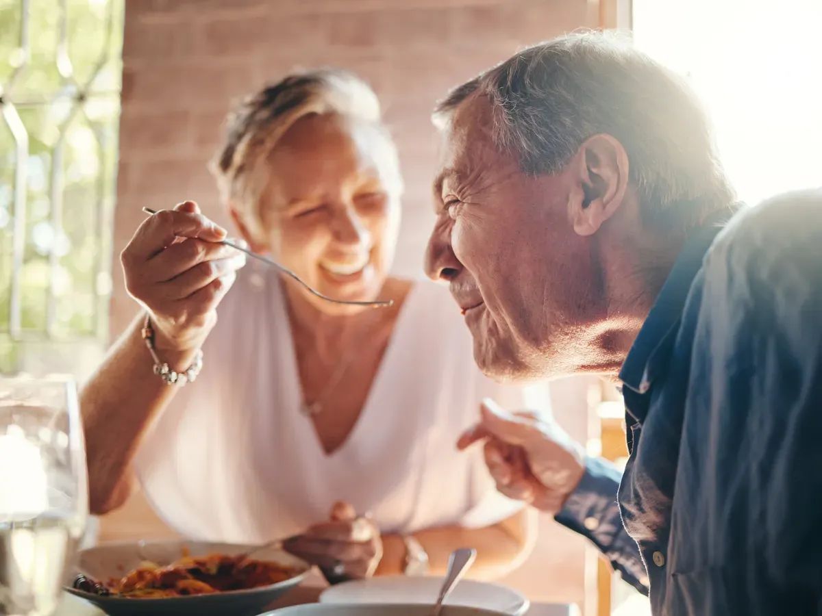 Un couple partage un repas à deux autour d'une table.