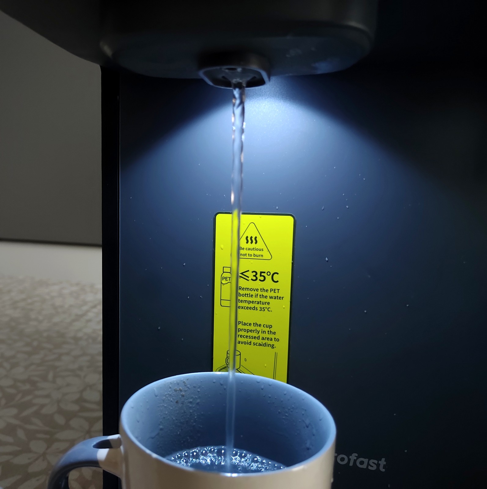 Le jet d'eau chaude sous l'éclairage de la machine.